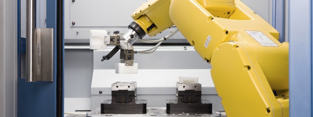 Robot laadt een bewerkingscentrum voor kunststof freesonderdelen